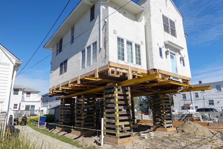 A team of professionals using specialized equipment to raise a house in Lancaster, preparing it for elevation and renovation